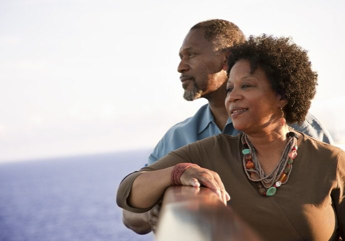 Mature African American couple on deck of a cruise ship, looking out into the ocean